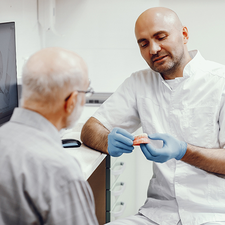 Dentist showing a denture to a patient