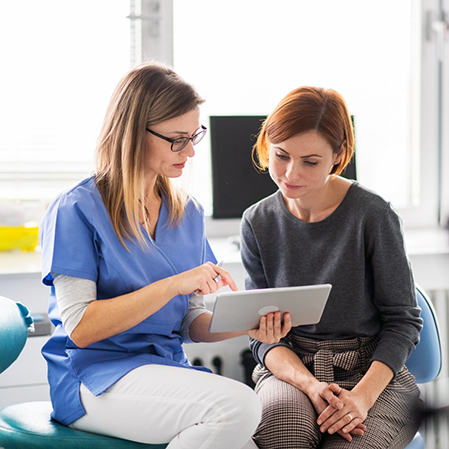 Dental team member showing a tablet to a patient