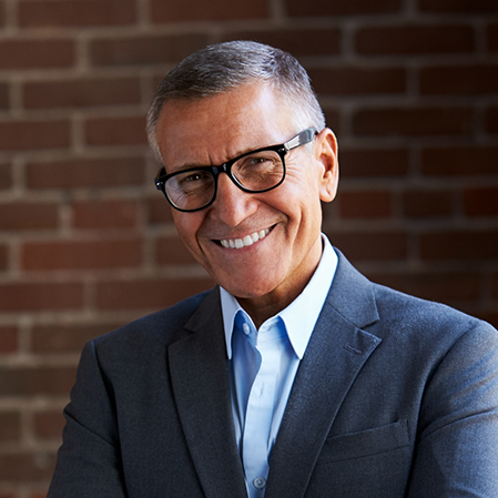 Smiling older man in a dark gray suit jacket