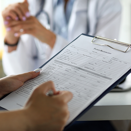 Person filling out a form on a clipboard