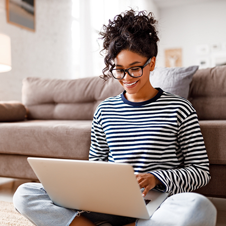 Woman smiling while typing on a laptop