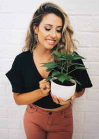 Young woman holding a potted plant