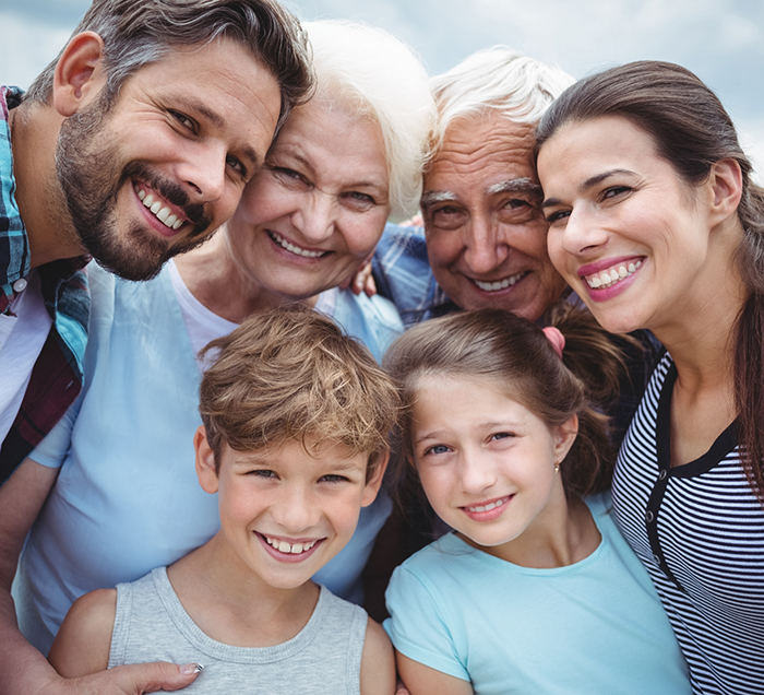 Three generations of a family smiling after preventive dentistry visit