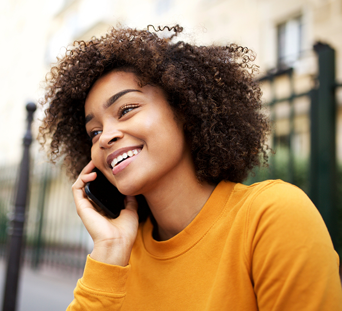 Young woman talking on the phone to request a dental appointment